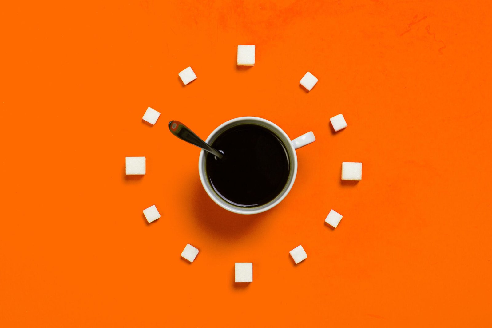A creative design for Coffee and cube sugars form a clock with orange background